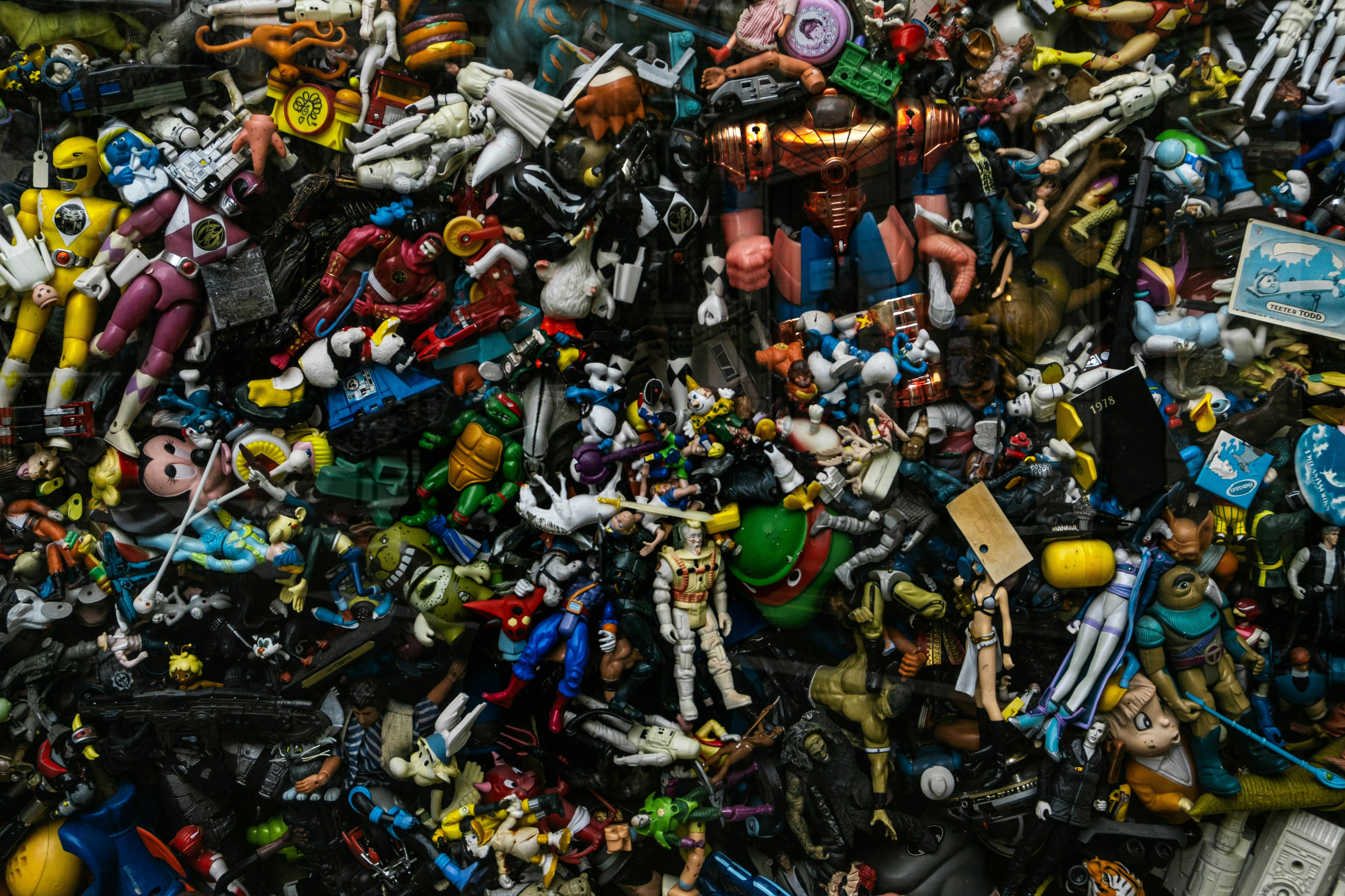 Large mixed pile of vintage and modern action figures including superheroes, cartoon characters, and toy soldiers, representing a diverse toy collection ready for resale or trade